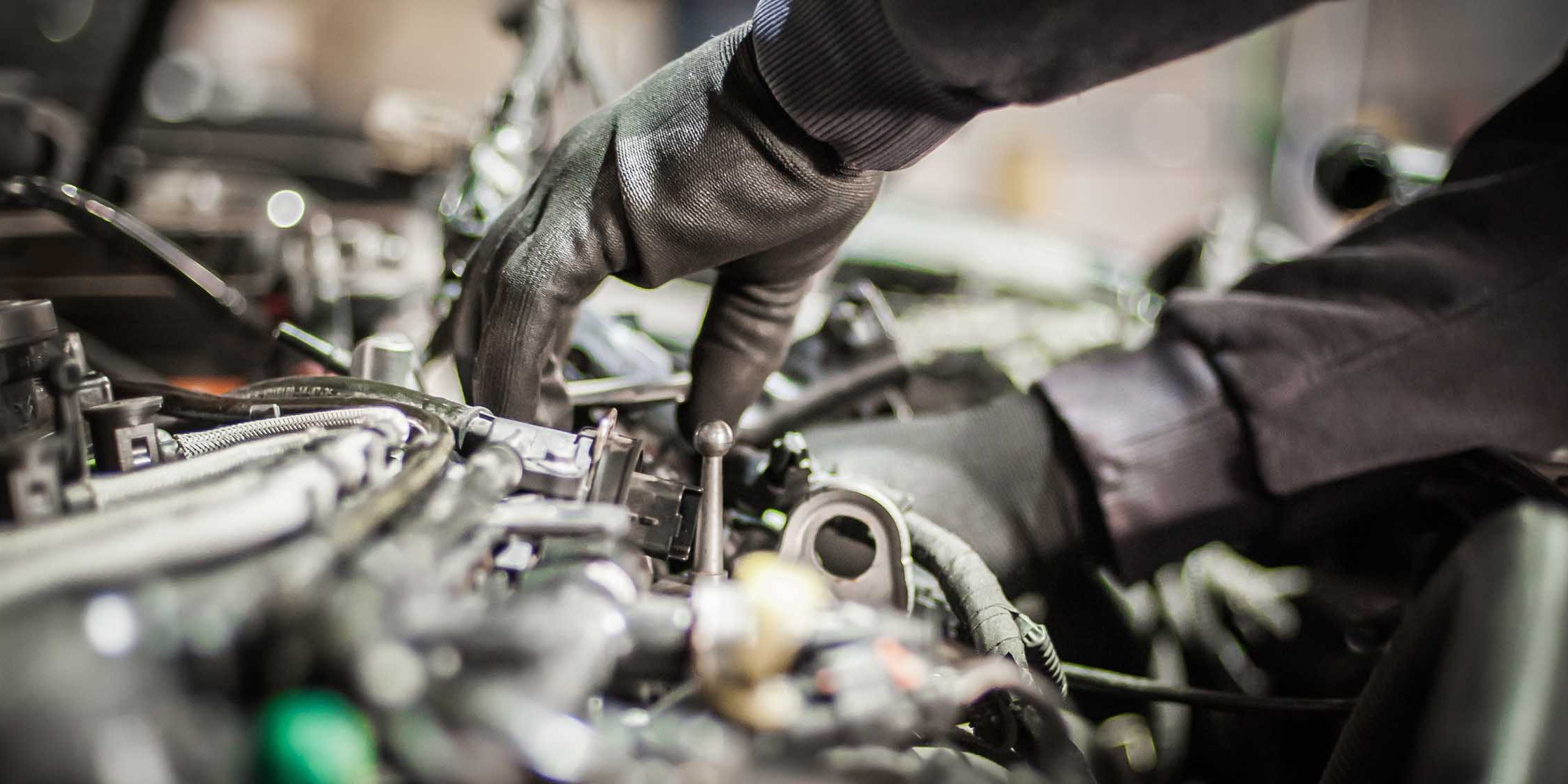 Close up of car mechanic repairer technician repairs auto engine. Close up of car master auto mechanic repairer service technician checks and repairs the engine condition under the hood of the vehicle service shop